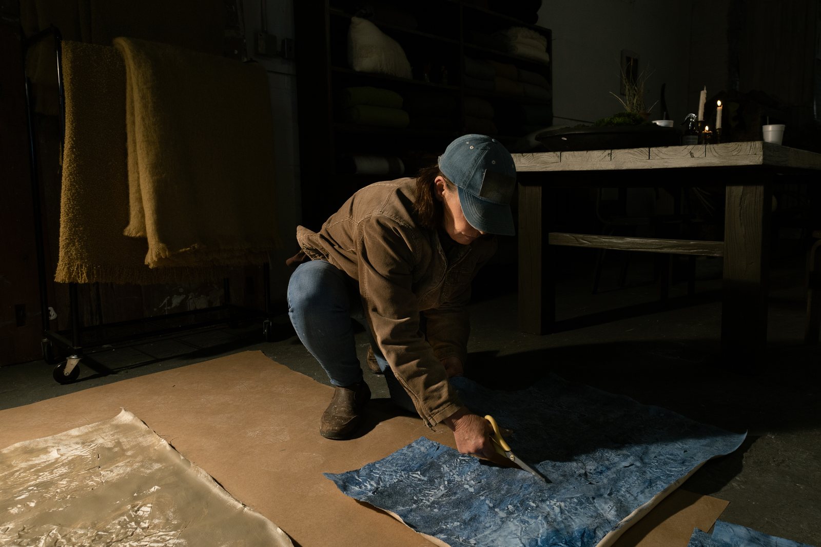 3A artist studios: an artist kneeling over large sheets of paper on the studio floor