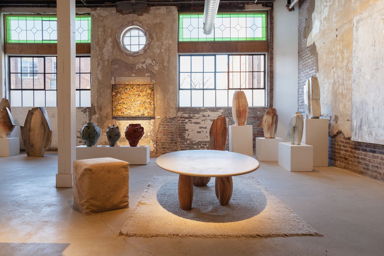 Round table and ceramics before brick and steel-sash windows