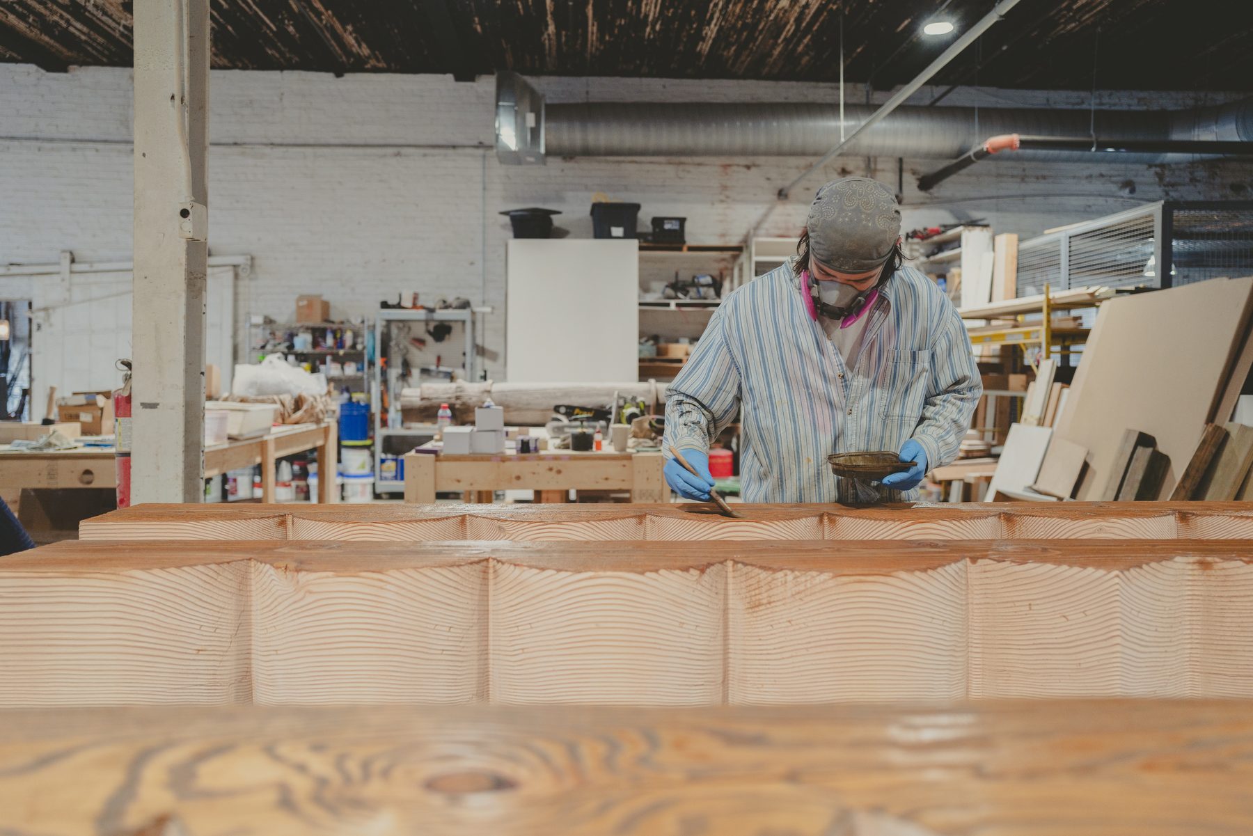 A maker finishing a timber piece in the 1B wood workshop