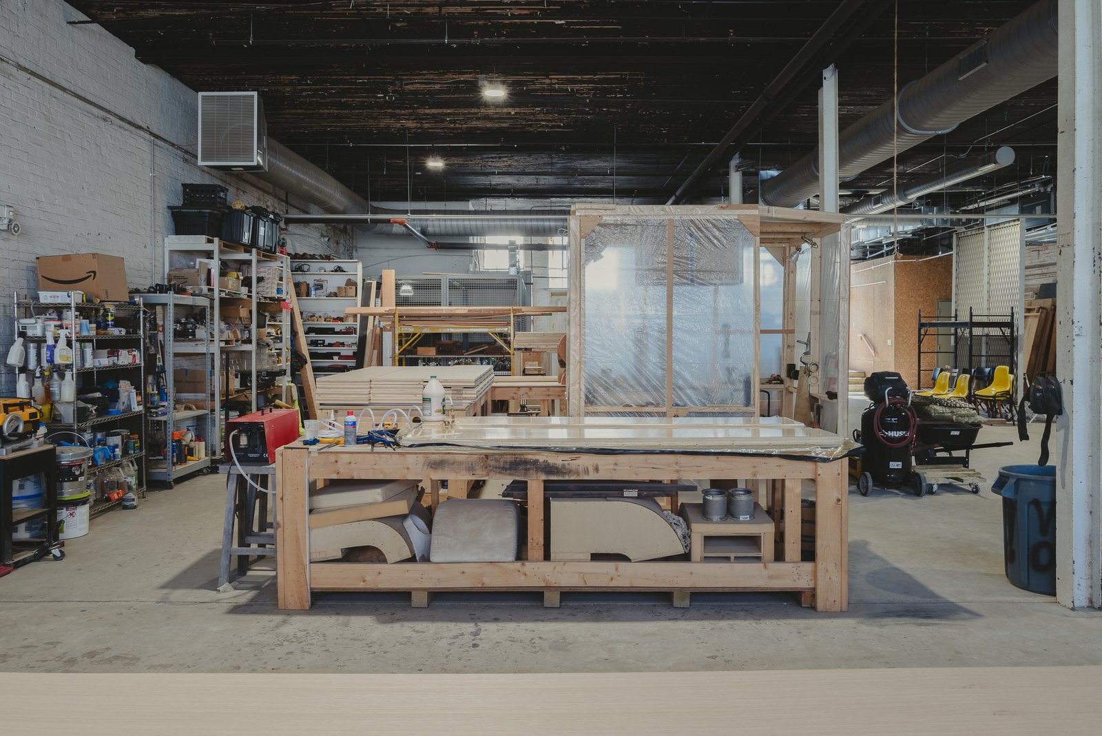 Wood shop with workbenches and tools under a timber ceiling