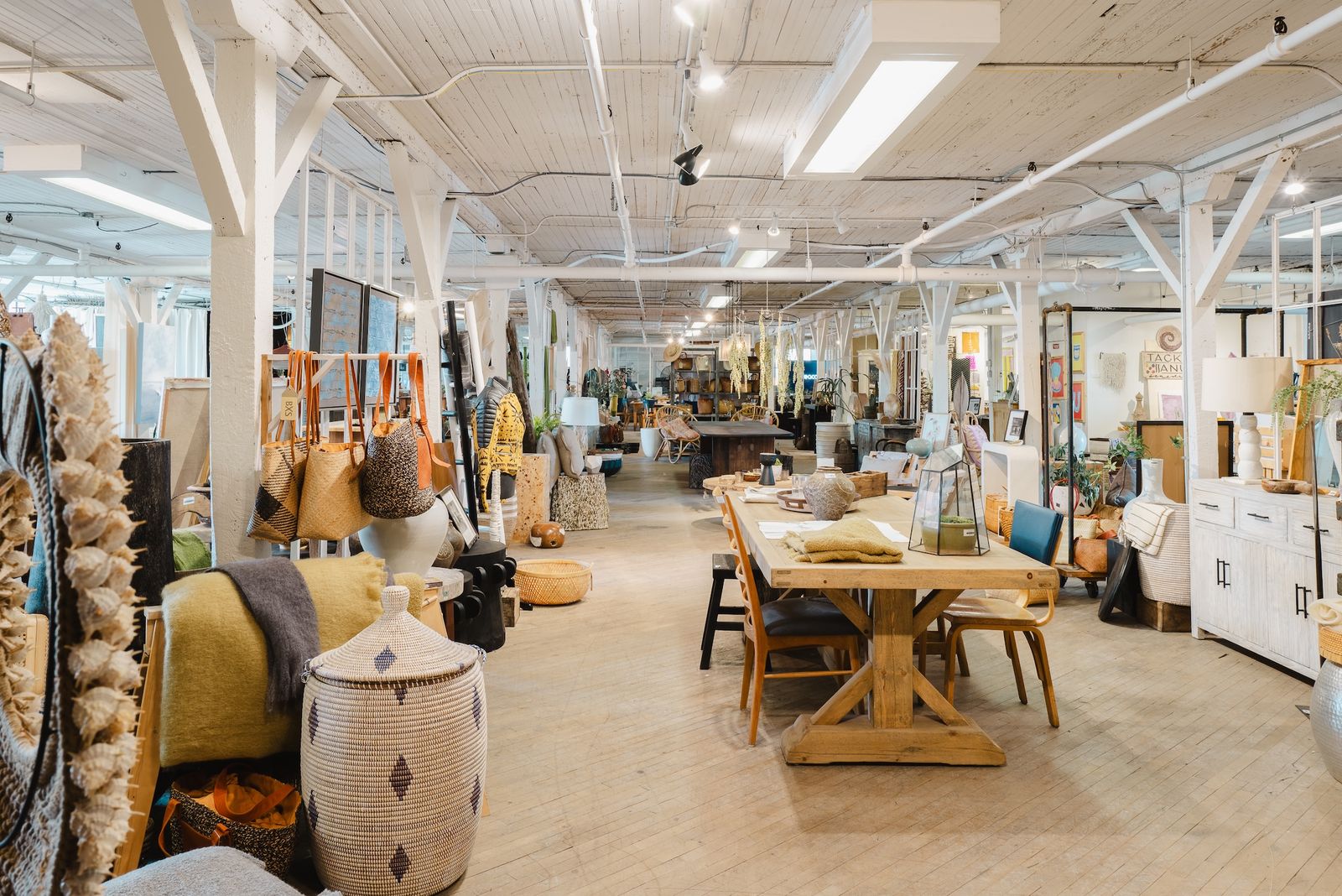 Second-floor showroom under timber trusses, set up for Market